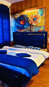 a bedroom with a blue and white bed with a flower mural at Basera Residency Shalimar in Bāgh Chandpura +12 photos