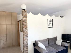 a living room with a couch and a brick pillar at Serenity home in Souda