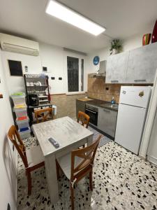 a kitchen with a table and chairs and a refrigerator at Al Duca 165 in Ladispoli
