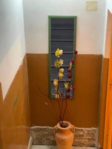 a flower in a vase in front of a window at Al Duca 165 in Ladispoli