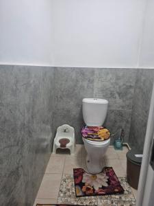 a bathroom with a toilet and a flower rug at Nur Guest House 17 in Saty