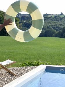a lifebuoy and a swimming pool with a lifesaver at La Petite Grange des Vignes in Jumilhac-le-Grand