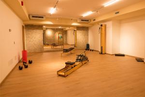 a gym with treadmills and dumbbells on a wooden floor at Hotel Lavaredo in Misurina