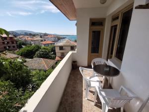 a balcony with a table and chairs and a view at Hotel VALDI in Ahtopol