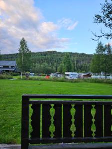 a park bench with a view of a field at Fossen Camping Fagernes in Døvre