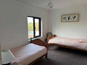 a bedroom with two beds and a window at Diamond View House in Letterfrack