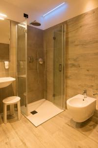 a bathroom with a shower and a sink and a toilet at Hotel Lavaredo in Misurina +80 photos