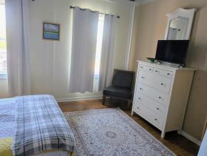 a bedroom with a bed and a dresser with a tv on it at 2 bed, 1 bath riverfront loft in Salisbury