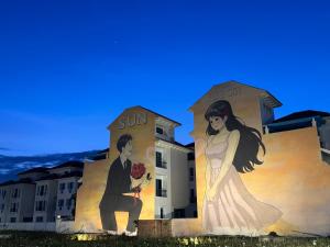 a mural of a bride and groom on the side of a building at 05 Homestay Cinema in An Khê