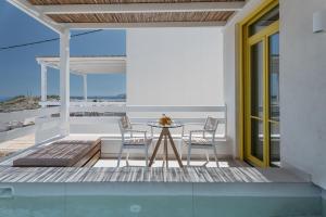 a patio with a table and chairs on a balcony at Asterry Suites in Kimolos
