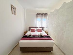 a bedroom with a bed with two pink pillows at Serenity home in Souda