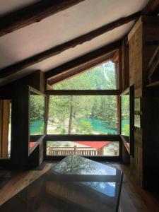 a large window in a room with a view of a forest at Rêve sur le lac in Rhêmes-Notre-Dame