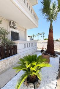 a patio with palm trees and a house at Serenity home in Souda