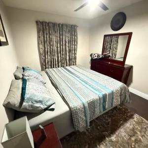 a small bedroom with a bed and a mirror at Luxury and Comfort in Coconut Creek