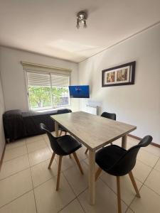 a dining room with a wooden table and chairs at Este Apart in Bahía Blanca