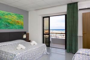 ein Schlafzimmer mit zwei Betten und Meerblick in der Unterkunft Hotel Côte D'Est in San Foca + 18 Fotos