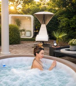 a woman sitting in a hot tub in a backyard at Villa Nuvola Suites in Fiorano Modenese