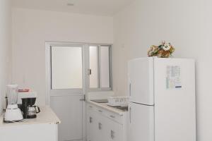 a kitchen with a white refrigerator and a window at Casa Viveros cerca de jardines 3 recamaras albercas y 2 estacionamientos in Jiutepec