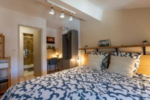 a bedroom with a blue and white bed with pillows at Appartement central - L'ouest in Tarare