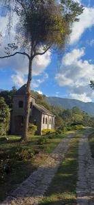 a tree next to a building with a road at Recanto da Serra e camping in Itamonte
