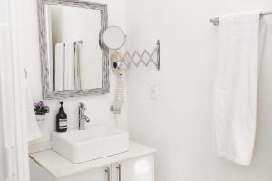 a white bathroom with a sink and a mirror at Casa Viveros cerca de jardines 3 recamaras albercas y 2 estacionamientos in Jiutepec +62 photos
