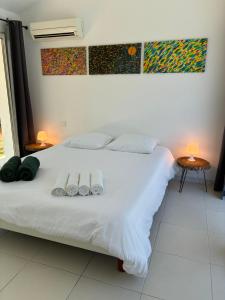a white bed with two pairs of shoes on it at Guest house Maison d'invités in Le Rouret +12 photos