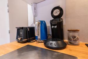 a counter with a coffee maker and a clock on it at Appartement central - L'ouest in Tarare