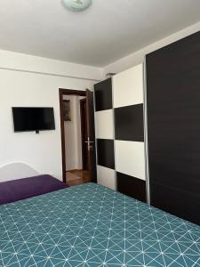 a bedroom with a bed and a flat screen tv at Lux dvosoban stan u centru Bara in Bar