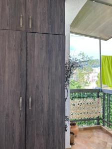 a room with wooden cabinets and a balcony at Lux dvosoban stan u centru Bara in Bar