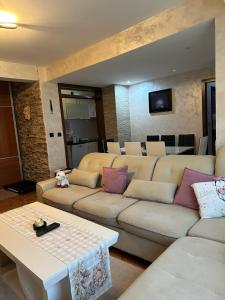 a living room with a couch and a table at Lux dvosoban stan u centru Bara in Bar