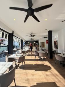 a ceiling fan in a restaurant with tables and chairs at Vibes Solution in Patong Beach