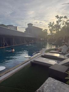a swimming pool with people in the water at Vibes Solution in Patong Beach