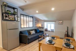 a living room with a couch and a table at Appartement central - L'ouest in Tarare
