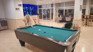 a woman playing pool in a room with a pool table at Студио Релакс, Ахелой in Aheloy