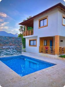a villa with a swimming pool in front of a house at Villa Campo Verde in Jarabacoa