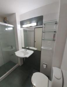 ein Badezimmer mit Waschbecken, Toilette und Spiegel in der Unterkunft Hotel Flores in Trinidad + 21 Fotos