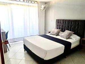 a bedroom with a large bed and a large window at Hotel Santander Plaza in Neiva