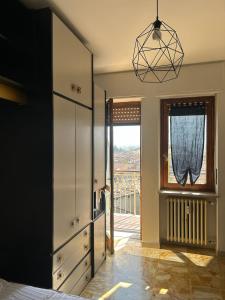 a room with a bedroom with a window and a chandelier at Alpine penthouse, breathtaking views! in Bussoleno