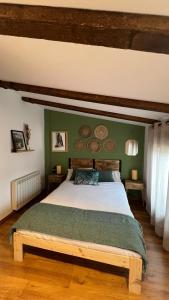 a bedroom with a large bed with green walls at Las Casitas de Martín in Candeleda