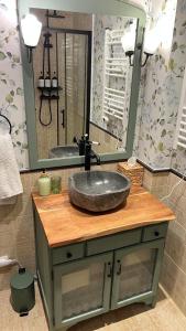 a bathroom with a sink and a large mirror at Las Casitas de Martín in Candeleda