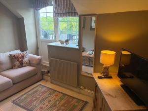a living room with a couch and a table with a lamp at The Hunters Rest Inn in Clutton