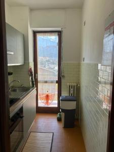 a kitchen with a window and a trash can at Alpine penthouse, breathtaking views! in Bussoleno +32 photos
