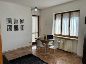 a dining room with a table and chairs and a laptop at Alpine penthouse, breathtaking views! in Bussoleno