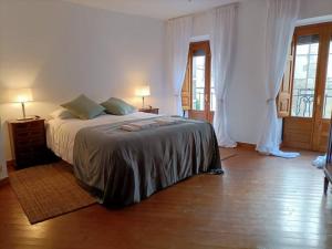 a bedroom with a bed and two lamps and windows at Casa Villamiel in Villamiel