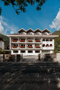 a white building with balconies on the side of it at Hotel Tiroler Adler in Lutago