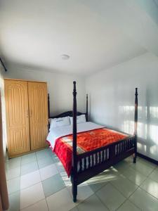 a bedroom with a bed with a red comforter at Naigara hotel and suites in Kampala