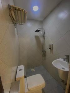 a small bathroom with a toilet and a sink at Naigara hotel and suites in Kampala