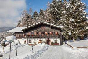 a building covered in snow with a snow covered road at Der Erlhof Restaurant & Landhotel in Zell am See