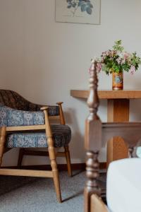 a living room with a chair and a table at Hotel Tiroler Adler in Lutago +36 photos