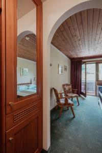 a room with a mirror and a chair and a bedroom at Hotel Tiroler Adler in Lutago